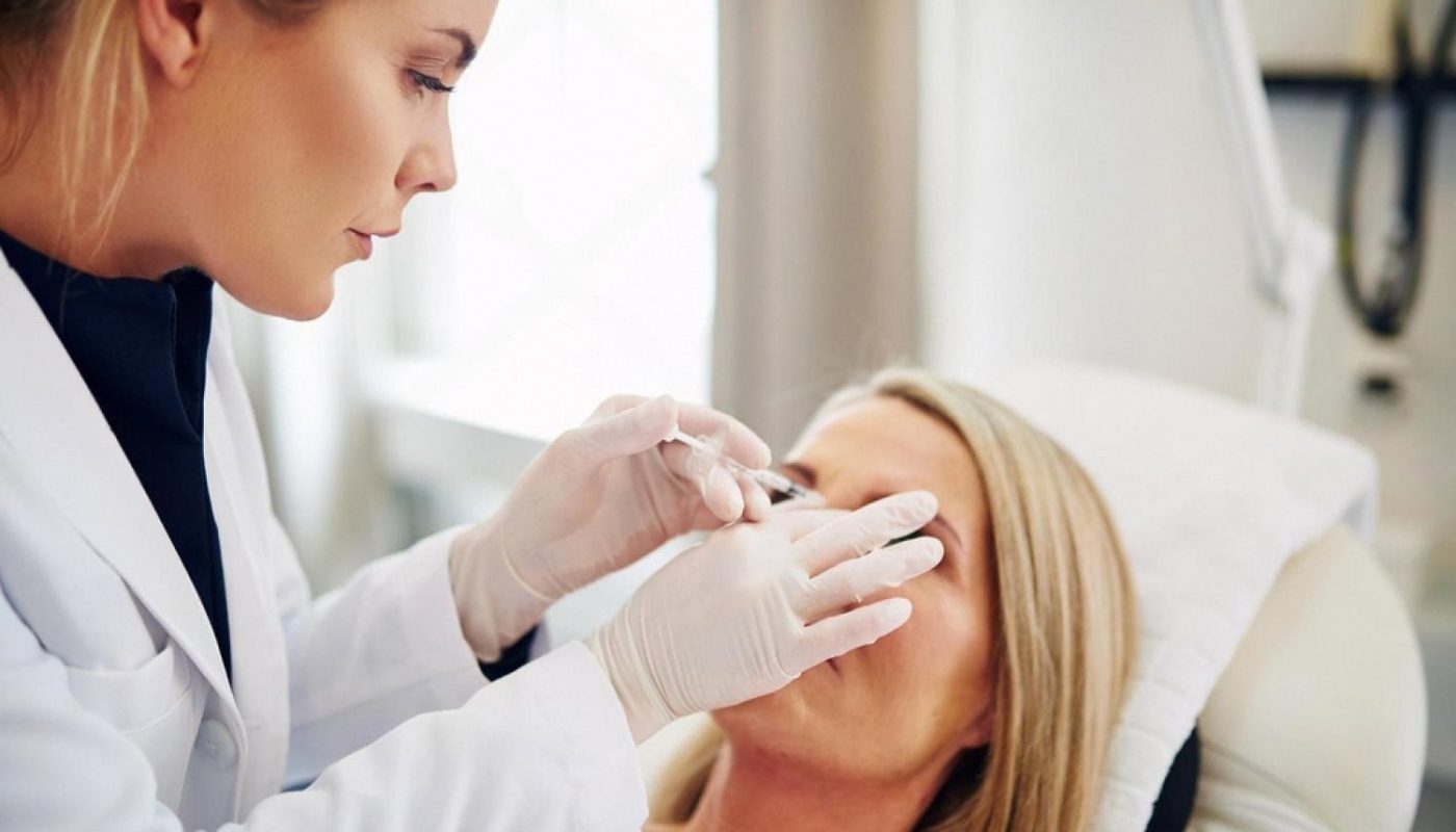 Dermatologist performing a close-up skin examination on a female patient in a UAE clinic