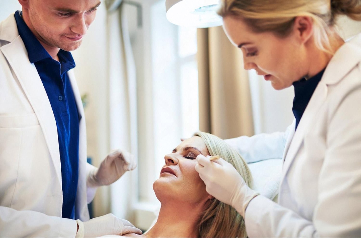 Two dermatologists reviewing a patient's skin condition during a consultation in Dubai
